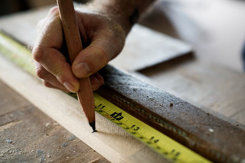 Parkett verlegen: Materialbedarf berechnen 5 Parkett Material wird mit einem Stift und Lineal berechnet.