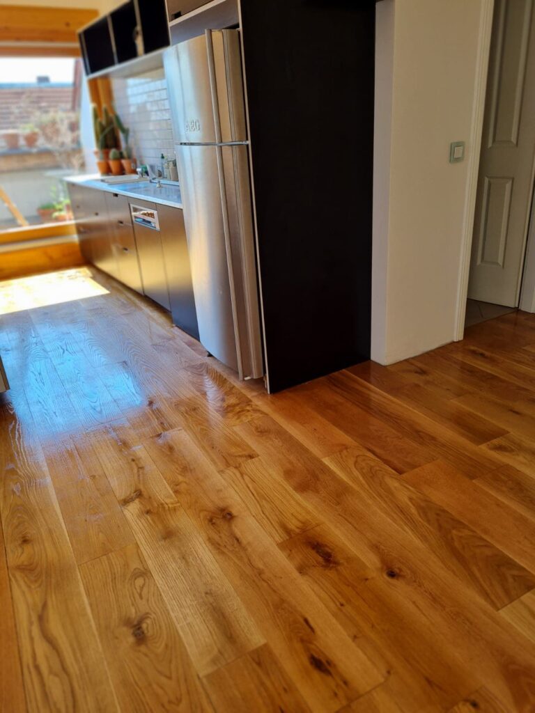 Parkett in der Küche mit Kühlschrank und Waschbecken.