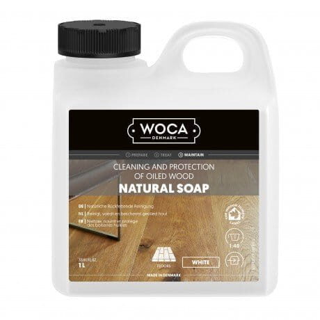 Ein 1-Liter-Behälter WOCA Naturseife zur Reinigung und zum Schutz von geöltem Holz, mit weißer Rezeptur und Kennzeichnung für den Pflegeeinsatz.