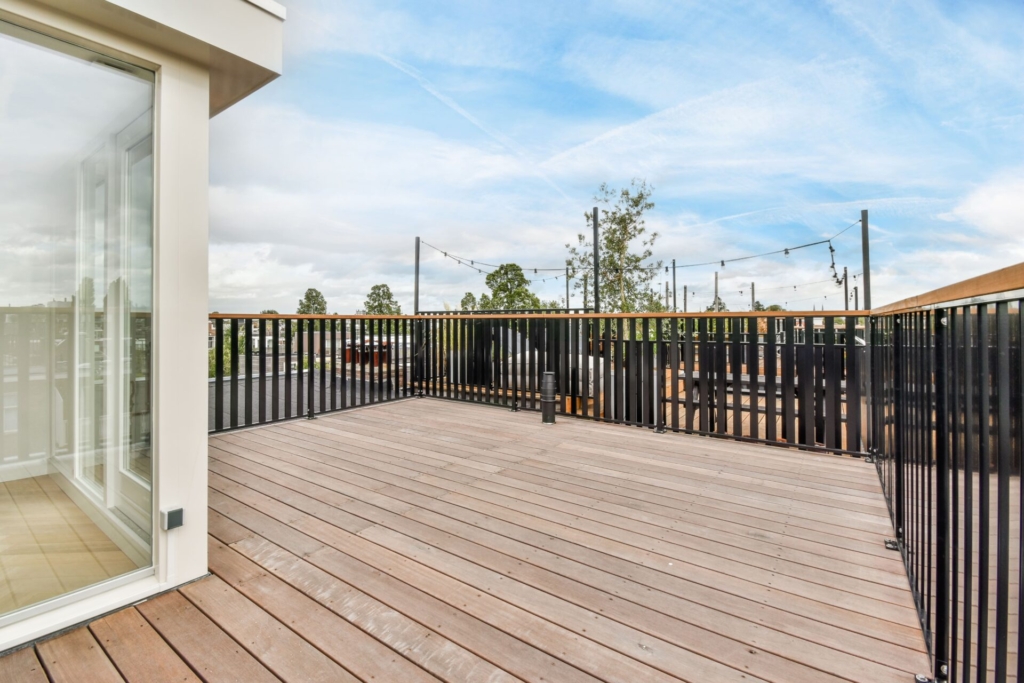 Eine Terrasse aus Holz mit einem Zaun und Stromleitungen im Hintergrund.