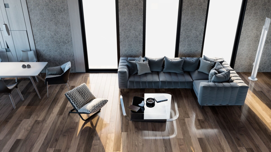 Modernes Wohnzimmer mit grauem Sektionssofa, gemustertem Sessel, Couchtisch aus Glas, Essecke und großen Fenstern, die natürliches Licht auf den Holzboden fallen lassen.