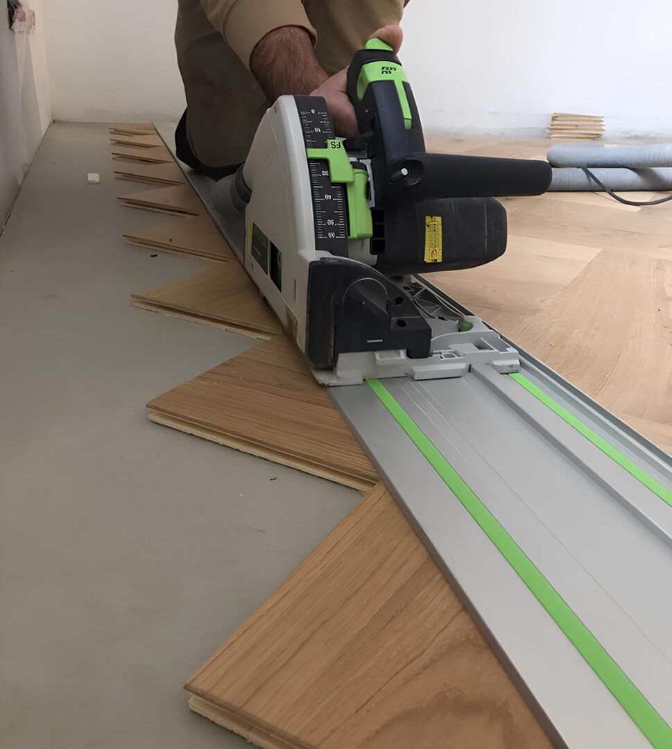 Handwerker schneidet präzise Holzstücke für Flechtparkett mit einer Tauchsäge auf einer Führungsschiene zu.