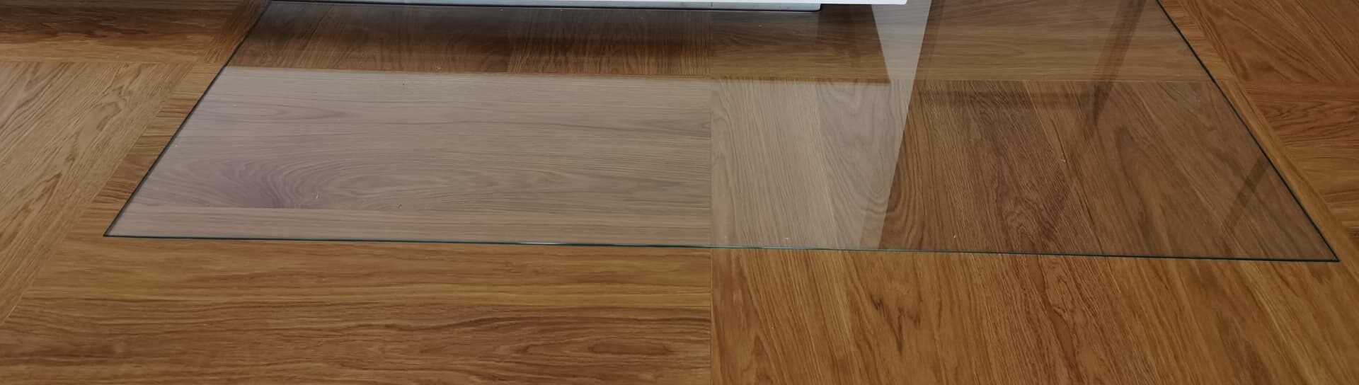 Glas-Funkenschutzplatte längs auf Parkettboden verlegt – Domke Parkett GmbH Berlin, elegante und sichere Lösung für Kaminbereiche