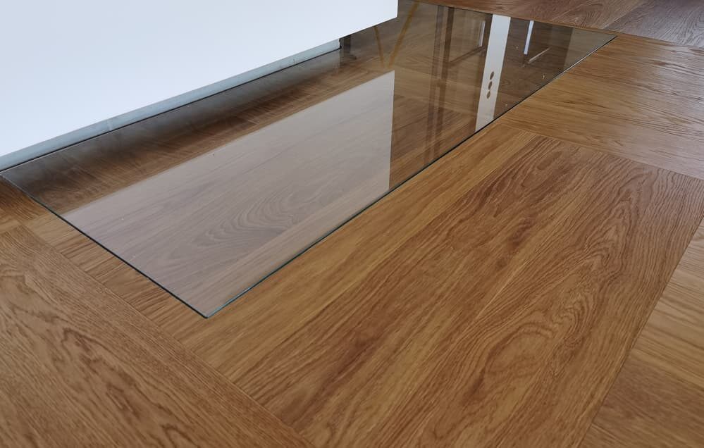 Glas-Funkenschutzplatte im Parkettboden integriert – Domke Parkett GmbH Berlin, stilvoller Schutz vor Funkenflug am Kamin