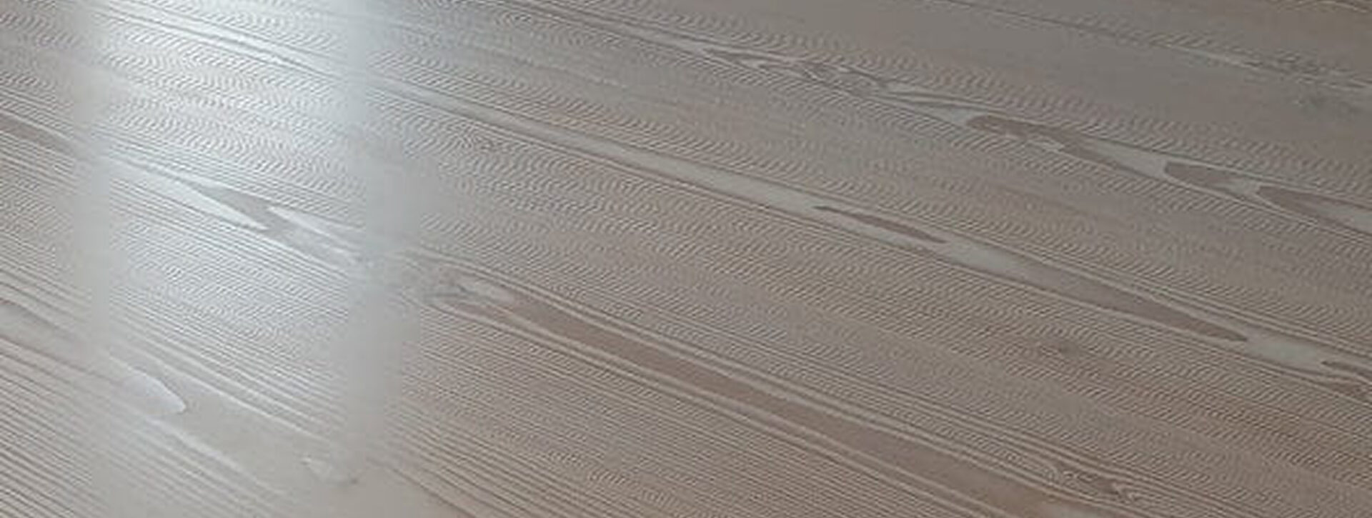 Detailaufnahme eines geölten und gewachsten Parkettbodens mit sichtbarer Maserung und matter Oberfläche.