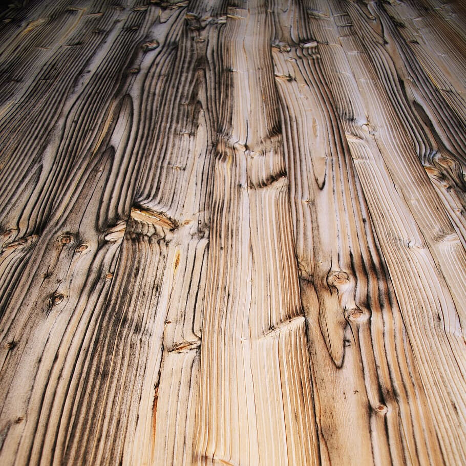 Detailaufnahme von rustikalen Holzbohlen mit ausgeprägter Maserung und dunklen Flammenstrukturen, ideal für einen natürlichen Bodenbelag oder Wandverkleidung im Shou-Sugi-Ban-Stil.