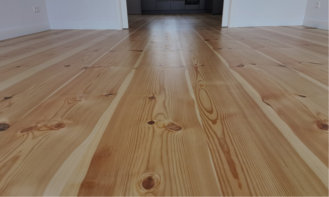 Verlegte Massivholzdielen über mehrere Räume in durchgehender Optik.